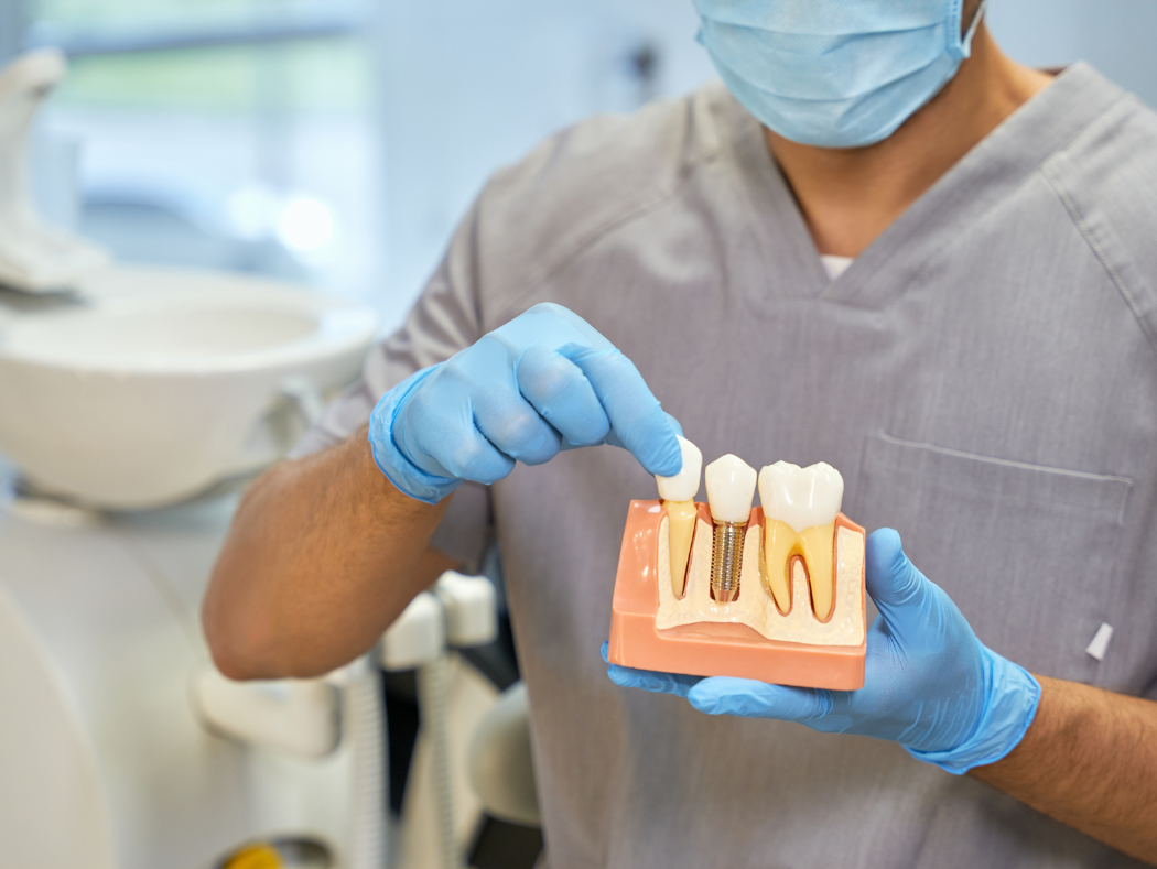 Dentist holding a personalized dental implant treatment plan with a patient in Louisville, KY